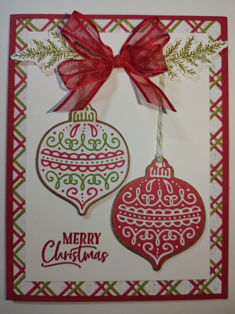 a card with Christmas ornaments that look like gingerbread cookies hanging from a pine bough